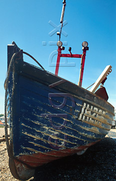 Comp image : boat0102 : Bow view of an old blue fishing boat with worn paint in heavy shadow against a clear blue sky