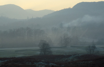 Comp image : ld01007 : View through cold evening mist across a wooded valley in the English Lake District