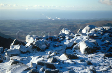 Comp image : ld04117 : Looking west from snow-covered Scafell Pike, in the English Lake District, in winter sun. Steam rising from Sellafield nuclear power station in the distance.