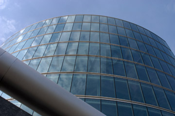 Comp image : lond010052 : Dramatic view looking up at a curved glass London building reflecting the blue sky
