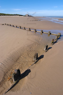 Comp image : shor022737 : A zigzag line of wooden posts in sunshine on a deserted sandy beach at low tide on the flat North Norfolk coast of England, under a clear blue sky