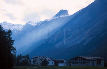 Comp image : sils0223 : A shaft of evening sunlight across the misty blue mountains over a Swiss village