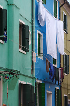 Comp image : ven021699 : Washing hangs out to dry outside brightly painted green and blue houses on the island of Burano, Venice, Italy