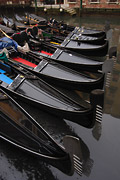The bows of black gondolas moored in Venice, Italy, form a fan shaped pattern
