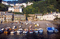 Fishing boats in the small harbour at Clovelly, Devon, England, with the buildings of the village on the steep hill in the background