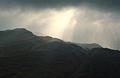 Heavy cloud and winter sunbeams over dark Lake District fells near Patterdale, seen from Place Fell