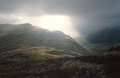Sun breaking through heavy cloud over Brothers Water and dark Lake District fells near Patterdale