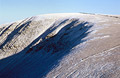 The distinctive curve of High Street, over Hayeswater, east of Hartsop, in the English Lake District, seen from Thornethwaite Crag in winter snow