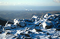 Looking west from snow-covered Scafell Pike, in the English Lake District, in winter sun. Steam rising from Sellafield nuclear power station in the distance.