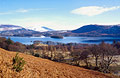 Looking over golden bracken in spring sunshine towards Derwentwater and Walla Crag, in the English Lake District, with Blencathra under snow in the distance.