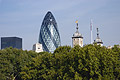 The old and the new: Sir Norman Foster's 'gherkin' and the historic Tower of London peer above the trees on the north bank of the River Thames in London, England