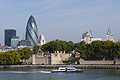 Old and new: Sir Norman Foster's 'gherkin' and the historic Tower of London seen from the south bank of the River Thames in London, England, with a boat in the mid distance