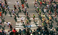 London Marathon 2000: overhead view of the pack of runners passing over 'Ahead Only' painted on the road in the Docklands area of London, at about half distance