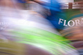 A strong blur of runners in the London Marathon, with part of the sponsor's (Flora) roadside advertisement in the background