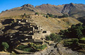 A Berber village of mud-brick houses nestling in the hillside across a valley in the High Atlas mountains of Morocco