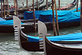 Bow 'flags' (ferri) and blue covers of gondolas moored on the Grand Canal in Venice, Italy. The six projections of the ferro symbolise the six districts (sestieri) of the city.