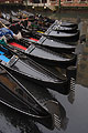 The bows of black gondolas moored in Venice, Italy, form a fan shaped pattern